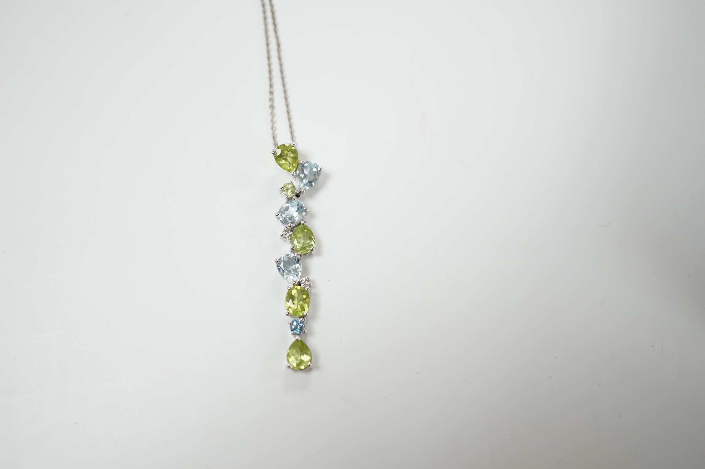 A modern 9ct white gold, peridot and blue topaz set pendant, 37mm, on a 375 chain, 40cm, gross weight 3.4 grams.